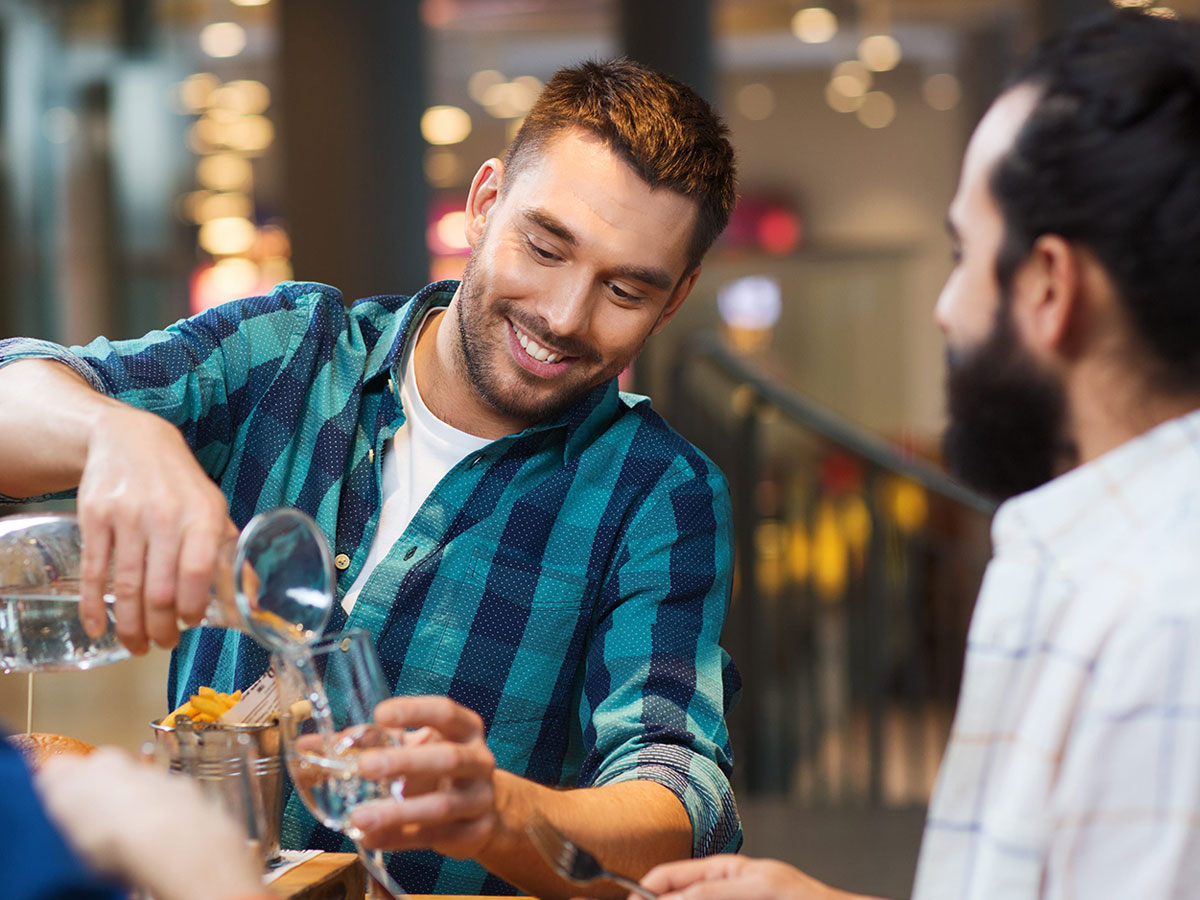 man pouring drink to celebrate after buying house and land sunshine coast 